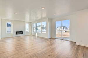 Unfurnished living room featuring a textured ceiling, LVP flooring, and a wealth of natural light