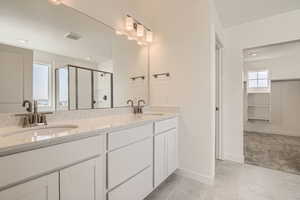 Bathroom with tile patterned flooring, vanity, and an enclosed shower