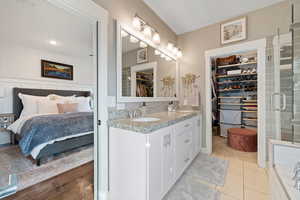 Bathroom with vanity, tile patterned floors, and a shower with door