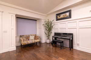 Sitting room with dark wood-type flooring and vaulted ceiling