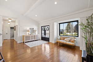 Entrance foyer featuring hardwood / wood-style flooring, beamed ceiling, high vaulted ceiling, and french doors