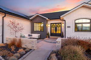 Exterior entry at dusk featuring french doors and solar panels