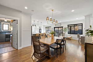 Dining space featuring hardwood / wood-style floors, independent washer and dryer, and a chandelier