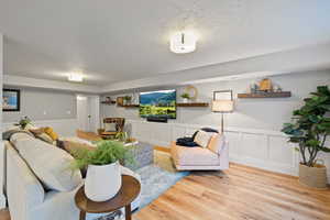 Living room featuring a textured ceiling and light hardwood / wood-style flooring