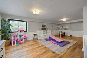 Playroom featuring a textured ceiling and hardwood / wood-style flooring