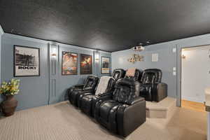 Cinema with hardwood / wood-style floors, a textured ceiling, and ornamental molding