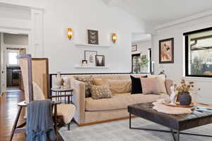 Living room with light wood-type flooring, lofted ceiling with beams, and a wealth of natural light