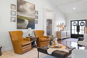 Living room featuring french doors, lofted ceiling with beams, and light hardwood / wood-style floors