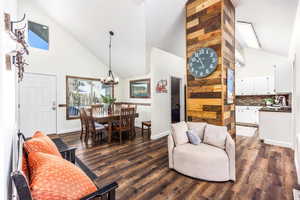 Living room featuring dark hardwood / wood-style flooring, sink, high vaulted ceiling, and a chandelier