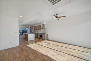 Unfurnished living room with ceiling fan, hardwood / wood-style floors, and sink