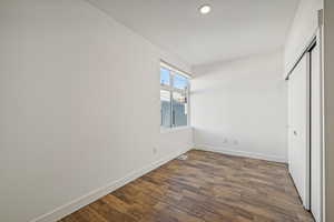 Unfurnished bedroom featuring dark wood-type flooring