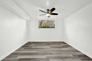 Empty room with hardwood / wood-style floors and ceiling fan