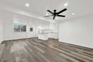 Unfurnished living room with hardwood / wood-style floors, ceiling fan, and sink