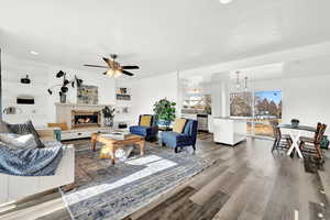 Living room featuring built in shelves, hardwood / wood-style flooring, and ceiling fan