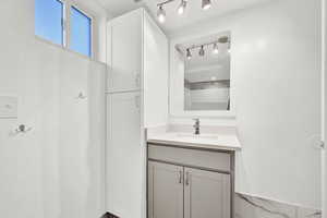 Bathroom with vanity and track lighting