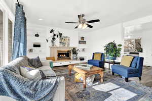 Living room with hardwood / wood-style flooring, ceiling fan, and built in features