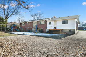 Rear view of house featuring a playground and central air condition unit