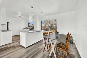 Kitchen featuring pendant lighting, light wood-type flooring, and white cabinetry