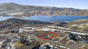 Snowy aerial view featuring a water and mountain view