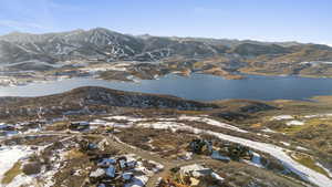 Snowy aerial view with a water and mountain view