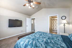 Carpeted bedroom with ensuite bath, ceiling fan, and lofted ceiling