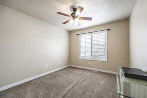 Unfurnished room featuring ceiling fan, carpet floors, and a textured ceiling