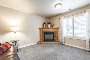 Living room featuring carpet flooring and a tile fireplace