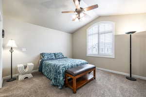 Bedroom with carpet, vaulted ceiling, and ceiling fan