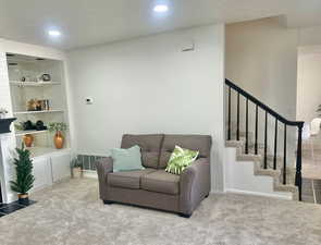 Living room featuring carpet floors and a textured ceiling