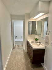 Bathroom with wood-type flooring, vanity, and shower / washtub combination