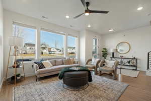 Living room featuring wood-type flooring, a wealth of natural light, and ceiling fan