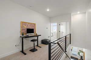 Home office with light colored carpet and heating unit