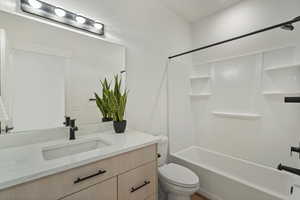 Full bathroom with vanity, shower / bathtub combination, and toilet