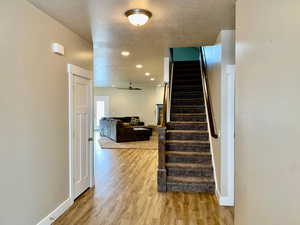 Stairway featuring wood-type flooring and a textured ceiling