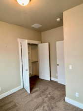 Unfurnished bedroom featuring a closet and carpet