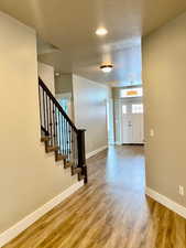 Entrance foyer with hardwood / wood-style floors and a textured ceiling