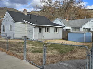 Rear view of property featuring a storage unit