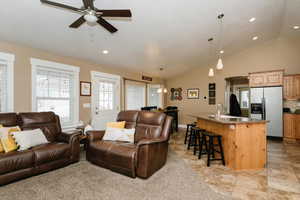 Living room with ceiling fan, sink, and lofted ceiling