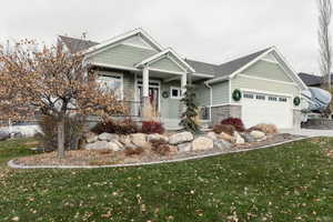 Craftsman-style home featuring a garage and a front lawn