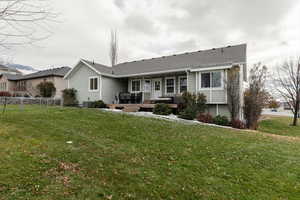 View of front of house featuring central AC unit, a front lawn, and a deck