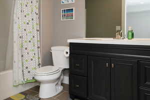 Full bathroom featuring tile patterned flooring, vanity, toilet, and shower / tub combo