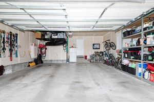 Garage featuring white fridge and a garage door opener