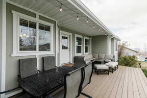 Wooden terrace featuring baseboard heating and an outdoor living space