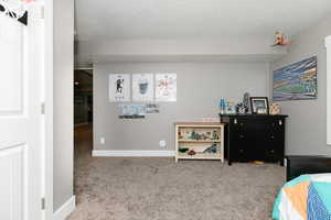 Bedroom featuring a textured ceiling and carpet floors