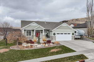 Craftsman inspired home with a front yard and a garage