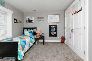 Bedroom featuring carpet floors and a textured ceiling