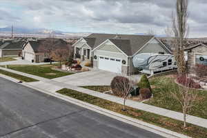 Ranch-style house with a mountain view, a front lawn, and a garage