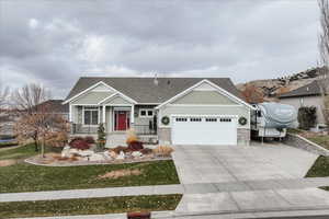 Craftsman-style home featuring a garage and a front lawn