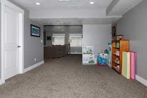 Interior space featuring carpet and a textured ceiling