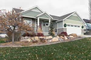 Craftsman-style home featuring a front yard and a garage